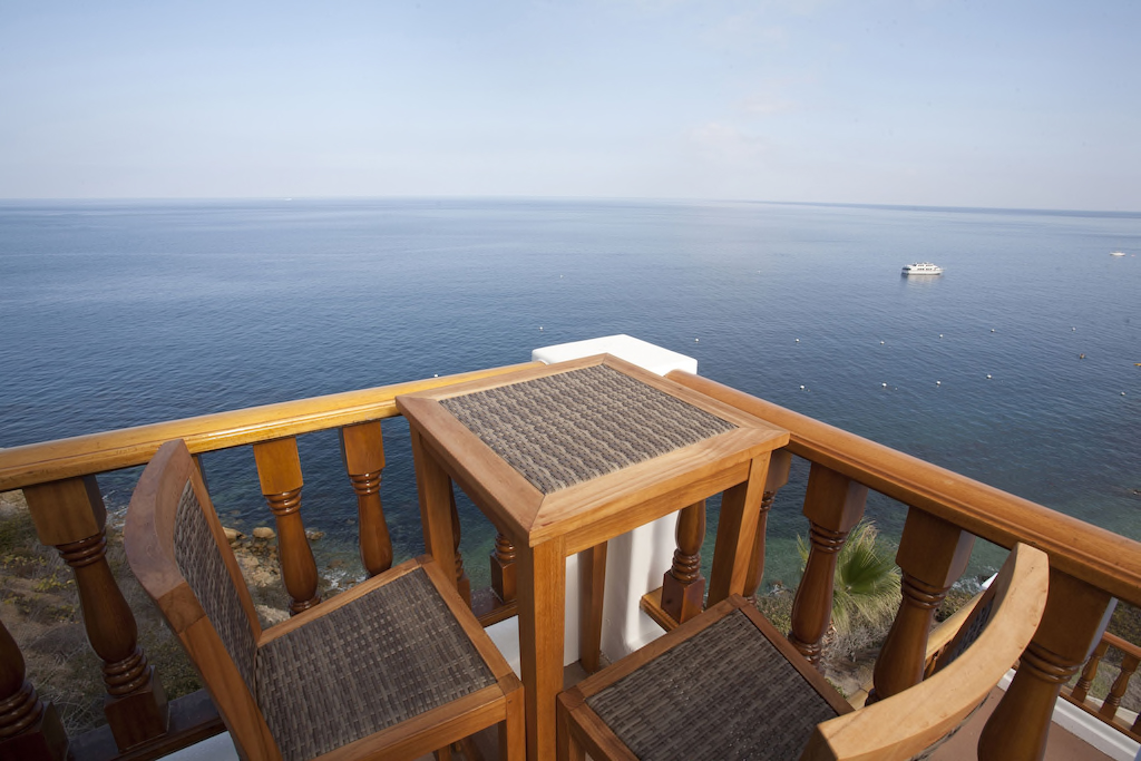 Balcony table and chairs above the ocean