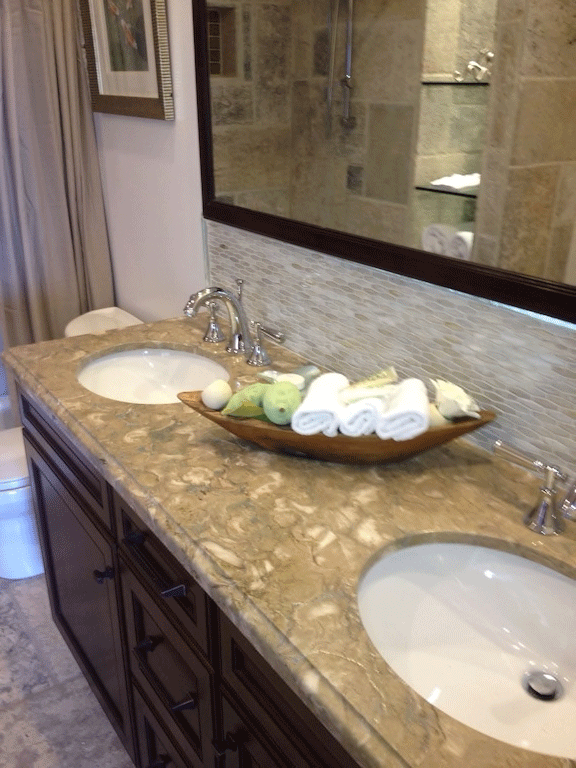 Bathroom vanity with rolled towels and stone counter